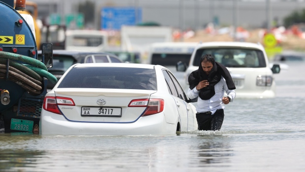 A driver walks through high water after abandoning his vehicle following a rainstorm in Dubai, United Arab Emirates, on Wednesday, April 17, 2024. The United Arab Emirates experienced its heaviest downpour since records began in 1949, Dubai’s media office said in a statement.