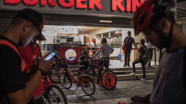 Food app delivery workers wait outside a Burger King Corp. restaurant in Sao Paulo, Brazil, in April, 2020.