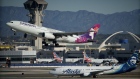 <p>A Hawaiian Airlines airplane takes off near an Alaska Airlines airplane at Los Angeles International Airport.</p>