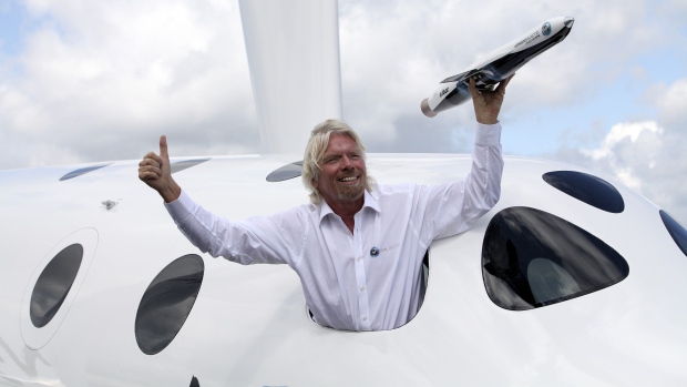 Richard Branson with a model of the LauncherOne rocket from the window of Virgin Galactic’s SpaceShipTwo at the Farnborough International Air Show in the U.K. in 2012. Photographer: Bloomberg