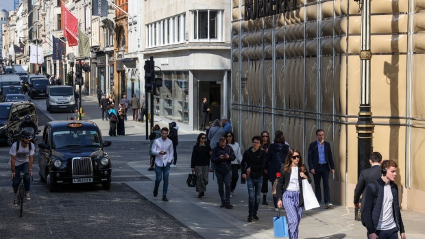 Shoppers pass high end shops on London's Bond Street. Known for