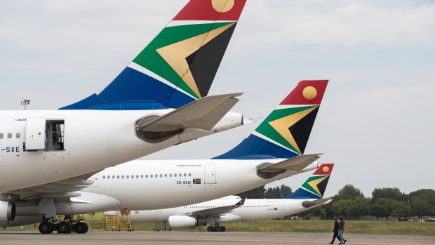 The logo of South African Airways sits on the tailfins of Airbus Group NV A340, left, and A330-200 aircraft parked at O.R. Tambo International airport in Johannesburg, South Africa, on Tuesday, Feb. 24, 2015.