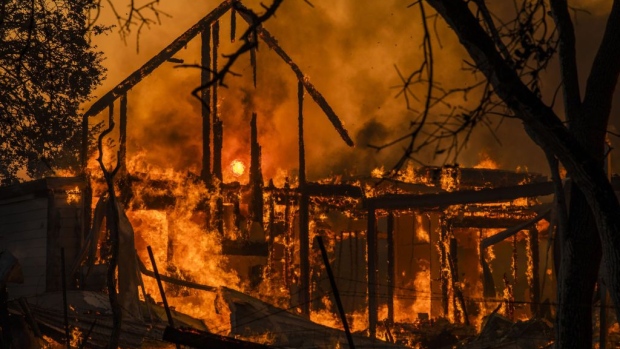 Flames engulf a home as it burns along Highway 128 during the Kincade fire in Healdsburg, California, U.S., on Sunday, Oct. 27, 2019. The wildfire that erupted in California's wine country minutes after a PG&E Corp. power line went down has prompted an expanded evacuation order, as officials warn high winds could drive the blaze toward one of the region's largest towns. Photographer: Bloomberg/Bloomberg