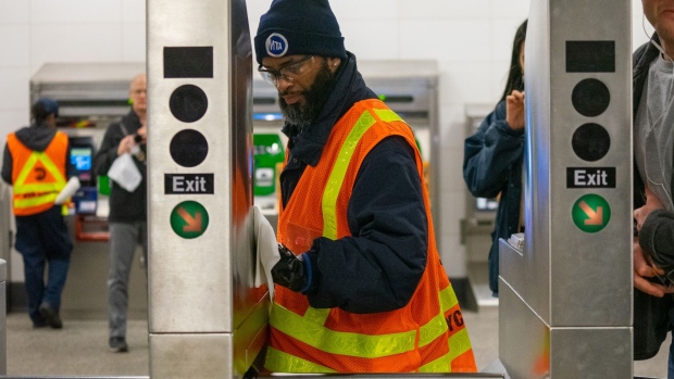 A Metropolitan Transportation Authority (MTA) worker sprays disinfectant and wipes a turnstile at the 86th subway station in New York, U.S., on Wednesday, March 4, 2020. Five more people were infected with the coronavirus in New York state, all linked to a 50-year-old lawyer who lives in Westchester County and works in Manhattan, Governor Andrew Cuomo said. Photographer: David Dee Delgado/Bloomberg