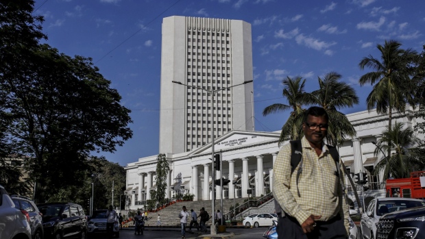A pedestrian walks past the Reserve Bank of India (RBI) in Mumbai, India, on Monday, March. 9, 2020. A top Indian official said there's no need for the government to take immediate steps to support the economy following a crash in oil prices that has sent financial markets into a tailspin. Photographer: Dhiraj Singh/Bloomberg