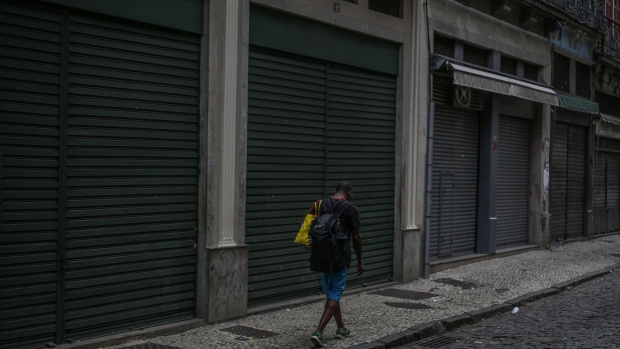 A pedestrian walks by closed stores on Uruguaiana Street in downtown Rio de Janeiro on April 16. Photographer: Andre Coelho/Bloomberg