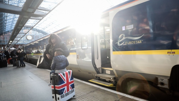 A young passenger sits on a suitcase featuring a design of the British Union Flag, also known as the Union Jack, on the platform after arriving on a train, operated by Eurostar International Ltd., at St. Pancras International railway station in London, U.K., on Thursday, Jan. 18, 2018. In Europe, the Eurostar high-speed rail from London to Paris and Brussels served 10 million riders last year, the fourth since it first topped that mark. Photographer: Simon Dawson/Bloomberg