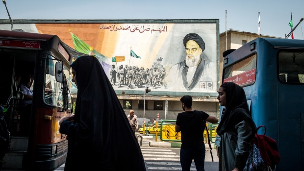 Pedestrians pass in front of political mural depicting Ruhollah Khomeini, founder of the Islamic republic of Iran, in Tehran.