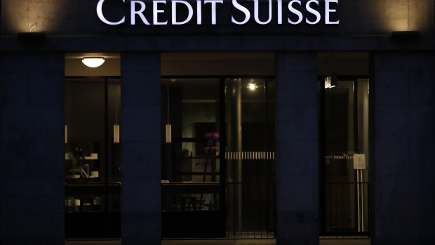 An illuminated logo hangs above the entrance to the Credit Suisse Group AG bank branch at night in Bern, Switzerland, on Friday, April 17, 2020. Credit Suisse compensated managers and employees with additional shares in the bank after the price dropped sharply during the depths of a market correction spurred by the coronavirus outbreak.