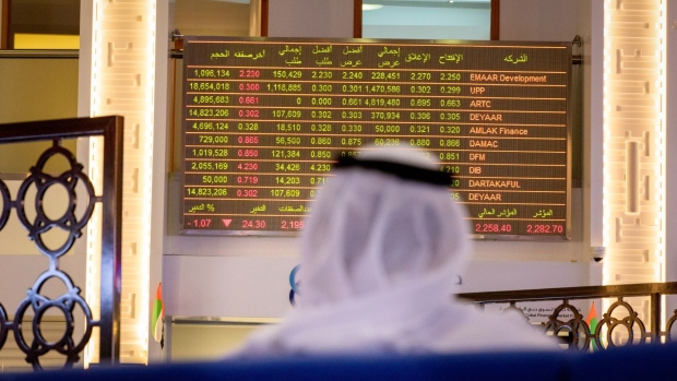 An investor watches stock price movements on an electronic screen at the Dubai Financial Market PJSC (DFM) in Dubai, United Arab Emirates, on Sunday, Sept. 6, 2020. Dubai made a rare foray into public bond markets, revealing along the way that its debt burden is now a lot smaller than estimated by analysts only months ago. Photographer: Christopher Pike/Bloomberg