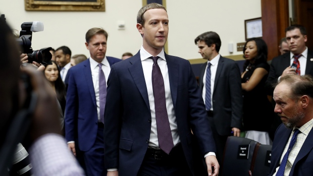 Mark Zuckerberg, chief executive officer and founder of Facebook Inc., center, arrives for a House Financial Services Committee hearing in Washington, D.C., U.S., on Wednesday, Oct. 23, 2019. Despite spending record amounts of money to influence Washington policy, Facebook's efforts to ingratiate itself so far have done little to assuage policy makers' privacy and antitrust concerns and in some cases have even made the company's challenges worse, according to first-hand accounts of its efforts.