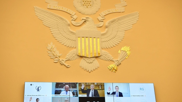 Mark Zuckerberg, chief executive officer and founder of Facebook Inc., top right, Jeff Bezos, founder and chief executive officer of Amazon.com Inc., top center, Sundar Pichai, chief executive officer of Alphabet Inc., bottom left, and Tim Cook, chief executive officer of Apple Inc., center left, are displayed on a monitor while swearing in during a House Judiciary Subcommittee hearing in Washington, D.C., U.S., on Wednesday, July 29, 2020.  Photographer: Mandel Ngan/AFP via Getty Images