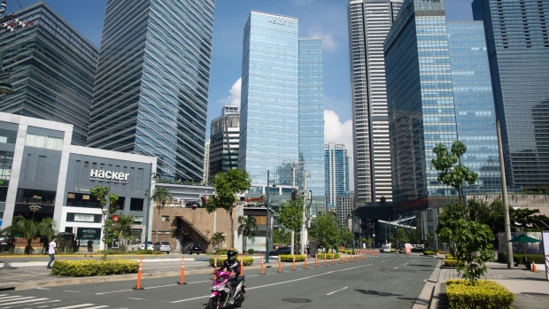 A motorcyclist travels along a deserted road in Bonifacio Global City, Metro Manila, the Philippines. on Monday, July 27, 2020. In his annual address to lawmakers today, Philippine President Rodrigo Duterte is expected to unveil an economic recovery roadmap. At the start of the coronavirus outbreak, Duterte said the disease would “die a natural death.” Five months later, the pandemic is raging, the economy is facing a deep contraction, and his political future could be at stake. Photographer: Geric Cruz/Bloomberg