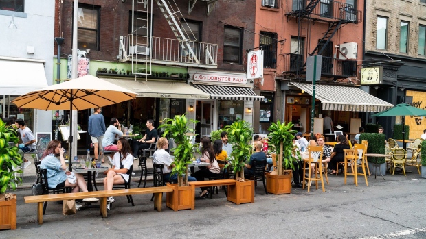 Customers sit in the outdoor dining area of a restaurant in New York, U.S., on Thursday, Dec. 10, 2020. New York City had its credit rating cut by Fitch Ratings because of the impact the coronavirus pandemic is having on the city's economy.