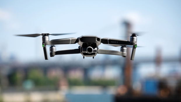 A SZ DJI Technology Co. Mavic 2 Zoom drone flies over the Brooklyn Navy Yard in the Brooklyn Borough of New York, U.S., on Thursday, Aug. 23, 2018. DJI introduced two additions to the Mavic series: the Mavic 2 Pro, with an integrated Hasselblad camera, and the Mavic 2 Zoom, a foldable consumer drone with optical zoom capability. Photographer: Mark Kauzlarich/Bloomberg