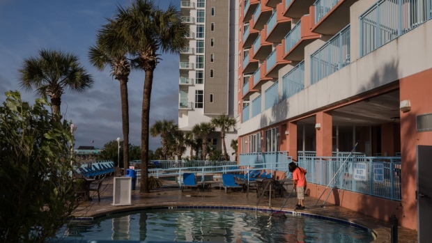A worker cleans the pool of a hotel in Myrtle Beach, South Carolina, U.S., on Sunday, April 11, 2021. South Carolina ranked number 2 on a list of the riskiest places to travel for spring break, according to a Quote Wizard report by Lending Tree. Photographer: Micah Green/Bloomberg