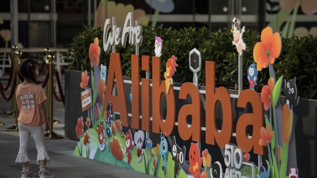 A girl stands in front of a sign at the Alibaba Group Holding Ltd. headquarters in Hangzhou, China, on Saturday, May 8, 2021. Alibaba is scheduled to report fourth-quarter results on May 13. Photographer: Qilai Shen/Bloomberg