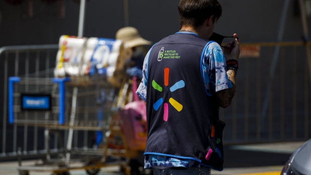 An employee adjusts a protective mask outside a Walmart store in Lakewood, California, U.S., on Thursday, July 16, 2020. Walmart Inc. will require customers to wear masks in all of its U.S. stores to protect against the coronavirus, an admission that the nation's pandemic has reached new heights and setting up potential confrontations with customers who refuse to don them. Photographer: Patrick T. Fallon/Bloomberg