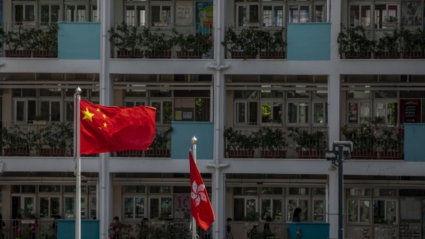 The flags of China, left, and of the Hong Kong Special Administrative Region (HKSAR) are flown in a school in Hong Kong, China, on Monday, June 29, 2020. The national security law that China could impose on Hong Kong as early as this week won't need to be used if the financial hub's residents avoid crossing certain "red lines," according to Bernard Chan, a top adviser to Hong Kong Chief Executive Carrie Lam. Photographer: Paul Yeung/Bloomberg