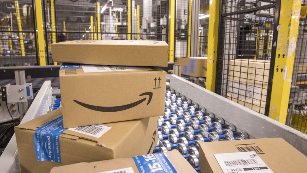 Packed boxes pass along a conveyor belt at the Amazon.com Inc. fulfilment centre in Tilbury, U.K. on Friday, July 12, 2019. By offering 12 extra hours of deals during this year's Prime Day, Amazon will pull in nearly 50% more in sales, according to an estimate from Coresight Research. Photographer: Jason Alden/Bloomberg