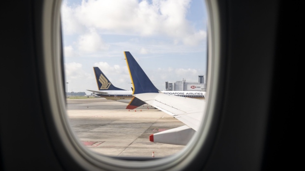 The wing of a Boeing Co. 737 Max 8 aircraft, operated by Singapore Airlines Ltd., from inside the cabin at the JetQuay CIP Terminal of Changi Airport in Singapore, on Tuesday, Nov. 16, 2021. Singapore Airlines unveiled its first new cabin offering in more than three years after spending S$230 million ($170 million) on the design and installation of seats on its 154-seat Boeing 737 Max planes. Photographer: Ore Huiying/Bloomberg