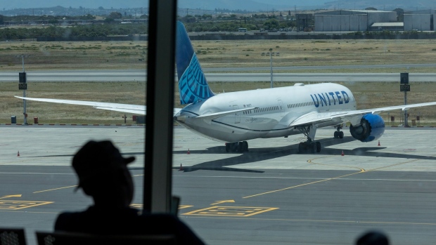 A United Airlines passenger aircraft taxis to the runway at Cape Town International Airport in Cape Town, South Africa, on Friday, Dec. 3, 2021. South Africa announced the discovery of a new variant, later named omicron, on Nov. 25 as cases began to spike and the strain spread across the globe, with many countries halting flights to and from southern Africa. Photographer: Dwayne Senior/Bloomberg