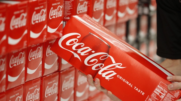 A worker restocks a display of Coca-Cola Co. soft drinks at a store in Orem, Utah, U.S., on Tuesday, Feb. 9, 2021. Coca Cola is scheduled to announce their fourth-quarter 2020 earnings tomorrow February 10. Coca-Cola Co.'s sales beat Wall Street's expectations in the fourth quarter, giving the soda maker a boost after nearly a year of global lockdowns at restaurants, amusement parks and stadiums that have disrupted its business. Photographer: George Frey/Bloomberg