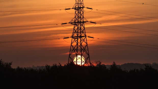 The sun rises beyond an electricity transmission tower near Rayleigh, U.K. Photographer: Chris Ratcliffe/Bloomberg