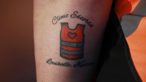 A volunteer with a "Clinic Escorts" tattoo outside the EMW Women's Surgical Center in Louisville, Kentucky. 