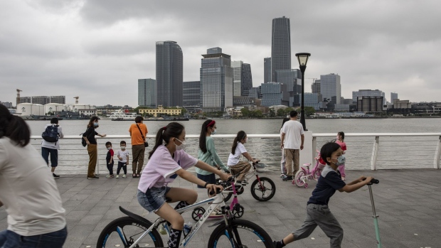 Children ride bikes and a scooter on a promenade along a river front in Shanghai, China, on Saturday, June 4, 2022. China declared victory over Shanghai’s coronavirus outbreak as the nation reported its fewest new cases in more than three months, vindicating Covid Zero in the eyes of Beijing despite the policy’s rising economic and social toll. Photographer: Qilai Shen/Bloomberg