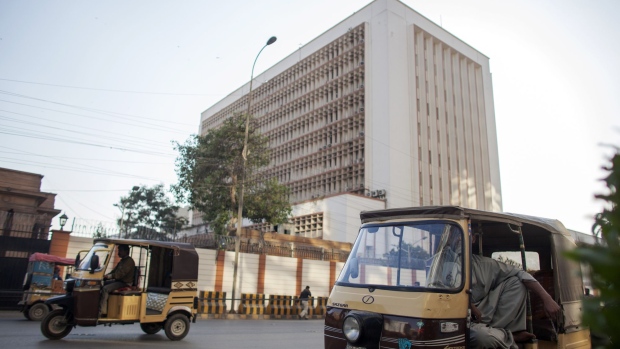Auto rickshaws travel past the State Bank of Pakistan building in Karachi, Pakistan, on Thursday, Dec. 14, 2017. Pakistan's rupee weakened to a record low after the central bank continued to ease its grip on the currency amid mounting economic pressure and speculation that the country may need International Monetary Fund support.