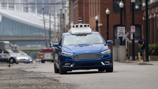 An Argo AI modified Ford Motor Co. Fusion autonomous vehicle is seen driving along a street near the company's headquarters in Pittsburgh, Pennsylvania, U.S., on Thursday, Aug. 16, 2018. The investment in Argo AI, a self-driving startup, is Ford's way of trying to catch up to Alphabet Inc.'s Waymo and General Motors Co. in the driverless derby. Ford took a majority stake in Argo last year and expects to deploy autonomous vehicles running its system in a money-making business by 2021.