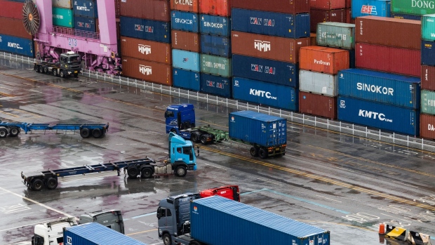 A truck travels past stacked containers at the Sun Kwang Newport Container Terminal (SNCT) in Incheon New Port in Incheon, South Korea, on Wednesday, June 15, 2022. Striking truckers in South Korea reached an agreement with the government, ending a weeklong strike that threatened the nation’s economy and added to strains on global supply chains. Photographer: SeongJoon Cho/Bloomberg