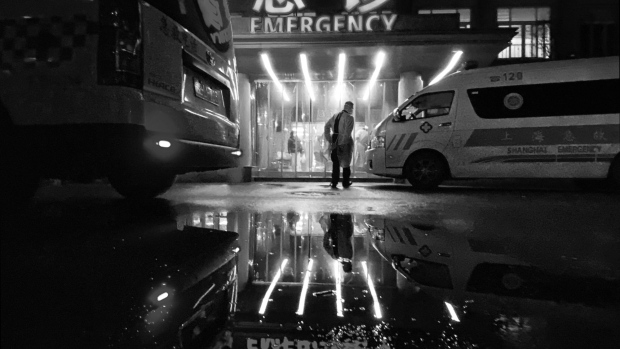 An ambulance driver walks into the ER of a hospital in Shanghia. Photographer: Kevin Frayer/Getty Images