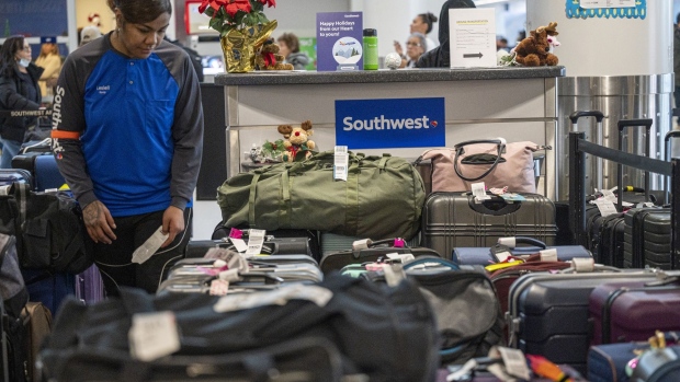 A Southwest Airlines worker looks for unclaimed luggage at Oakland International Airport (OAK) in Oakland, California, US, on Wednesday, Dec. 28, 2022. Families hoping to catch a Southwest Airlines Co. flight after days of cancellations, missing luggage and missed family connections suffered through another wave of scrubbed flights, with another 2,500 pulled from arrival and departure boards Wednesday. Photographer: David Paul Morris/Bloomberg