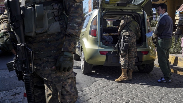 Members of the military search a vehicle at a checkpoint in Soyapango, El Salvador, on Dec. 5, 2022.