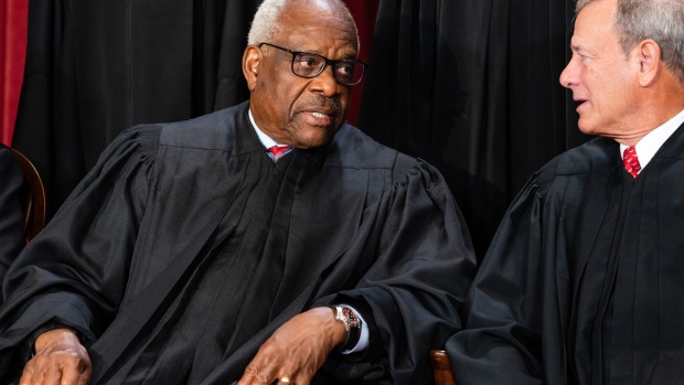 Associate Justice Clarence Thomas, left, talks to Chief Justice John Roberts during the formal group photograph at the Supreme Court in Washington, DC, US, on Friday, Oct. 7, 2022.
