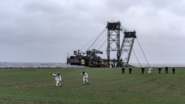 Police attempt to prevent environmental activists from approaching an excavator at the RWE AG Garzweiler open-cast lignite mine in Germany during a January protest. Photographer: Ben Kilb/Bloomberg