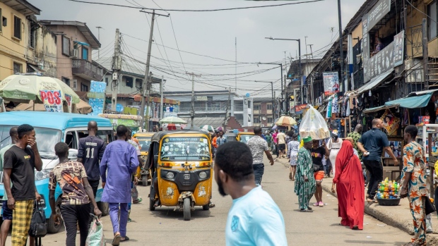 Pedestrians and auto-rickshaws make their way down a street in Lagos, Nigeria, on Saturday, Sept. 24, 2022. Nigeria's inflation rate hit a fresh 17-year high in August, placing renewed pressure on the central bank to increase interest rates. Photographer: Damilola Onafuwa/Bloomberg