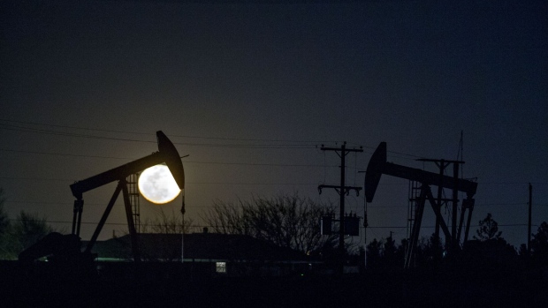 The silhouette of pumpjacks are seen as the moon rises in the Permian Basin near Midland, Texas, U.S., on Friday, March 2, 2018. Chevron, the world's third-largest publicly traded oil producer, is spending $3.3 billion this year in the Permian and an additional $1 billion in other shale basins. Its expansion will further bolster U.S. oil output, which already exceeds 10 million barrels a day, surpassing the record set in 1970. Photographer: Daniel Acker/Bloomberg