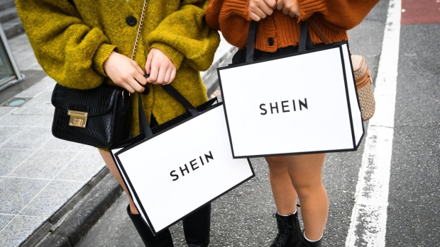 Customers hold Shein bags outside the Shein Tokyo showroom in Tokyo, Japan, on Sunday, Nov. 13, 2022. Fast fashion retailer Shein opened its first permanent store in the world in the Harajuku district of Tokyo on Sunday, Nov. 13. Photographer: Noriko Hayashi/Bloomberg