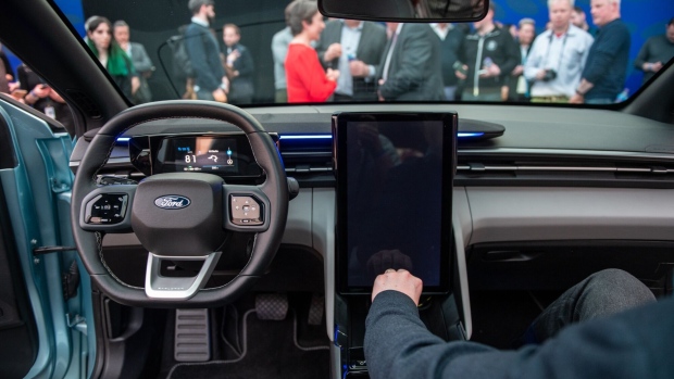 Attendees look at the interior, including a movable 14.6-inch touchscreen, in the Ford Motor Co. Explorer electric sport utility vehicle (SUV) during its launch in London, UK, on Tuesday, March 21, 2023. Ford will build it at the EV campus in Cologne, Germany, where it's invested $1 billion as part of broader plans to transition its European passenger car lineup entirely to electric models by the end of the decade.