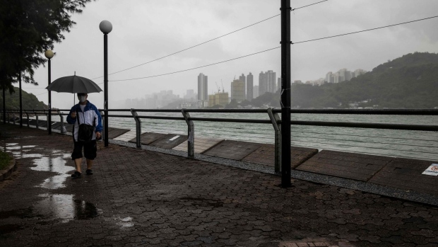 A man walks along the waterfront in Hong Kong on August, 25, 2022, amid a typhoon warning as Severe Tropical Storm Ma-on passed closest to the city in the early morning.  Photographer: Isaac Lawrence/AFP/Getty Images