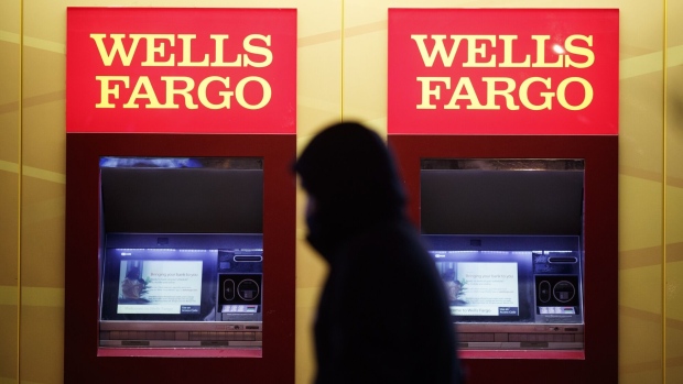 A pedestrian walks past automated teller machines (ATM) at a Wells Fargo bank branch at night in Washington, D.C., U.S., on Thursday, Jan. 7, 2021. Wells Fargo & Co. is scheduled to release earnings figures on January 15.