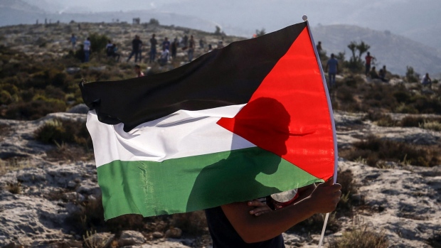 A Palestinian protester waves a Palestinian flag during a demonstration in the village of Ras Karkar west of Ramallah in the occupied West Bank on September 4, 2018.  Photographer: Abbas Momani/AFP/Getty Images