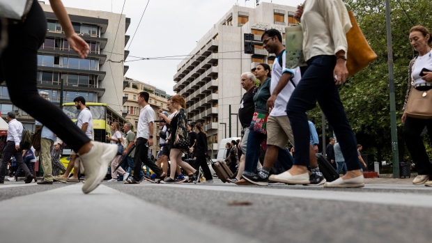 Pedestrians cross a road in Athens, Greece, on Thursday, Sept. 7, 2023. DBRS Morningstar is set to update its assessment on Friday, with markets expecting it will join Scope Ratings and Rating and Investment Information Inc. in placing Greece at investment level. Photographer: Yorgos Karahalis/Bloomberg