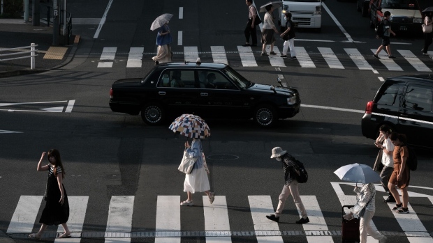 Pedestrians cross a street in the Nakano district of Tokyo, Japan, on Monday, July 10, 2023. Eastern and western Japan will have a 60% chance of above-normal temperatures over the next monthly period, the Japan Meteorological Agency said in a forecast released last week. Photographer: Soichiro Koriyama/Bloomberg