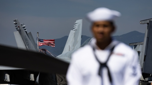 A US national flag flies on board the USS Ronald Reagan, a Nimitz-class aircraft carrier and part of the US Navy 7th Fleet, anchored in Busan, South Korea, on Friday, Sept. 23, 2022.  Photographer: SeongJoon Cho/Bloomberg