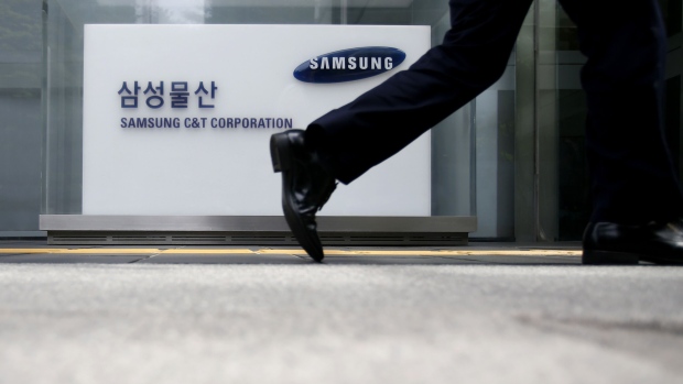 A pedestrian walks past a signage for Samsung C&T Corp. at the company's headquarters in Seoul, South Korea, on Friday, July 17, 2015.  Photographer: SeongJoon Cho/Bloomberg
