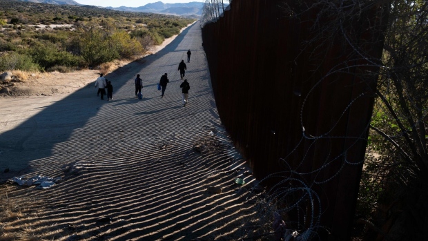 Migrants after entering the United States through a gap in the border wall in Jacumba Hot Springs, California, US, on Tuesday, Nov. 7, 2023. Mexican President Andres Manuel Lopez Obrador will take a proposal to reduce the flow of migrants up north for discussion with US counterpart Joe Biden after agreeing on a common strategy with other Latin American nations.